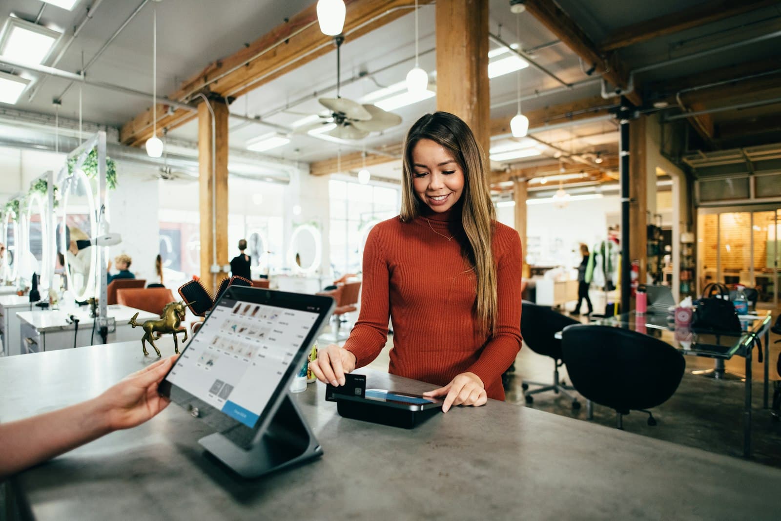 A customer paying with a card at a small business counter.