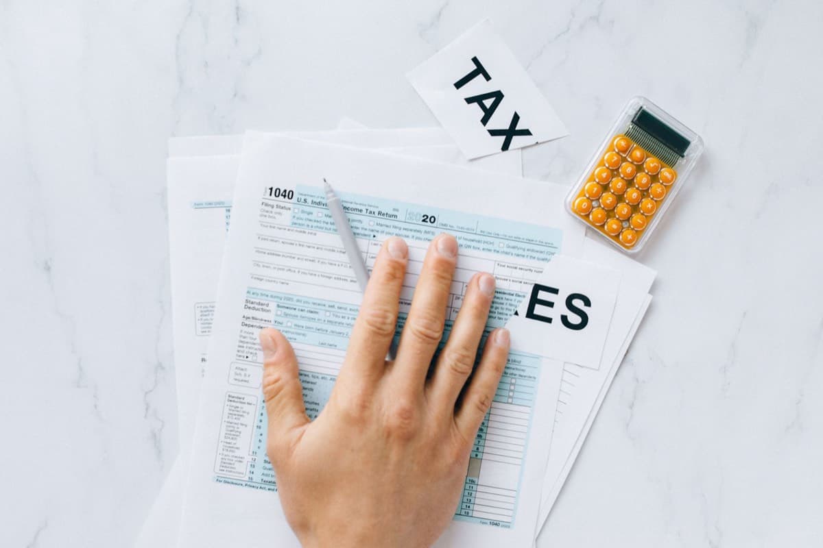 Rental-property receipts and a tax form with a calculator on a desk, keeping property expense records.